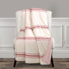 a white chair with a red and white striped blanket on it's back side