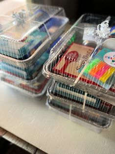 several plastic containers filled with different types of crafting supplies on top of a table