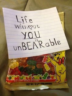 a bag of gummy bears sitting on top of a bed next to a note that says life without you unbearable