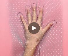 a person's hand on top of a pink sheet with white polka dotes