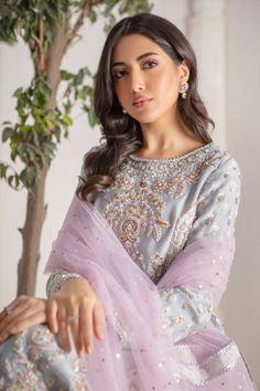 Refreshing Ice blue hued, relaxed silhouette shirt crafted from Pure silk net, fully hand block printed and embellished with tila , dabka, opaque sequins, beads, pearls over a myriad of colorful floral embroidery stylized beautifully. Stunning lilac net dupatta with heavily sprinkled sequins, finished with block printed borders and gota borders adds a fun festive element. This stunning kurta is paired with jamawar izaar pants to complete the look of this outfit, perfect for all celebratory festivities. Shirt Fabric: Pure Silk Net Shirt Length: 48” (customisable, mention in order notes) Pant Fabric: Jamawar Dupatta Fabric: Net Shirt & Pant Color: Ice Blue Dupatta Color: Lilac snow This outfit is fully lined Please refer Size Guide Before selecting size For Customised measurements please sel Party Wear Hand Embellished Blouse For Festive Season, Hand Embellished Blouse Piece For Party Wear, Festive Hand Embellished Party Wear Blouse Piece, Festive Hand Embellished Party Wear Blouse, Hand Embellished Semi-stitched Georgette Blouse Piece, Semi-stitched Hand Embellished Georgette Blouse Piece, Hand Embellished Chinon Salwar Kameez, Hand Embellished Georgette Sets With Long Sleeves, Hand Embellished Long Sleeve Georgette Sharara