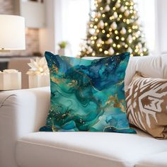 a christmas tree is in the background behind a couch with pillows on it and a lamp