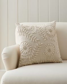 a white couch with a decorative pillow on it's back and armrests