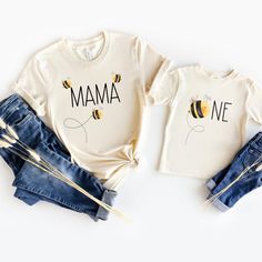 two t - shirts with the words mama and one bee on them, sitting next to each other