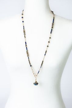 Longer in design, with a stunning labradorite focal, this handcrafted collage necklace features shades of blue with gold filled elements. Ideal for wearing as a solo statement piece, or layered with other items. Gold Filled (Lead & Nickel Free) Lapis, Pyrite, Labradorite 32.5-34.5" adjustable with gold filled lobster claw clasp We hand select our natural materials, thus there may be slight variations in color and/or size that will not detract from the overall aesthetic. Our unique handcrafted de Bohemian Blue Labradorite Necklace, Blue Labradorite Jewelry With Natural Stones, Artisan Blue Labradorite Necklace, Blue Labradorite Gemstone Bead Necklaces, Blue Labradorite Gemstone Beads Necklace, Blue Labradorite Jewelry With Gemstone Beads, Blue Labradorite Gemstone Beads Jewelry, Blue Labradorite Beaded Jewelry, Blue Labradorite Necklaces For Healing