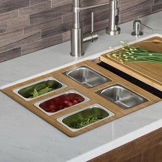 the kitchen sink has four compartments with vegetables in them