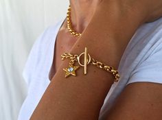 24K Gold plated chunky bracelet, Gold Star bracelet, Gold star charm. This bracelet is made with 24K Gold plated brass rolo chain and gold plated zamak Star with strass, and toggle. Rolo chain link: 6.3x2.5mm Star charm: 20,2x17,8 mm Zamak is a great alternative to solid sterling silver for the budget conscious buyer, it is just as pretty and durable and it is stain less. All silver pieces are subjected to an anti-allergic process ( nickel and lead free). All our designs are handmade, each piece Gold Chain Bracelet With Star Charm, Gold Metal Chain Bracelet With Star Charm, Gold Bracelet With Star Charm, Gold Metal Bracelets With Star Charm, Handmade Star-shaped Gold Bracelets, Gold Metal Bracelet With Star Charm, Gold Star Charm Bracelet, Gold Star Charm Chain Bracelet, 14k Gold Star Charm Bracelet