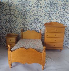 a dollhouse bedroom with a bed, dresser and night stand