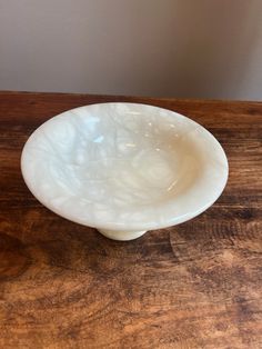 a white bowl sitting on top of a wooden table