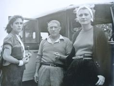 an old black and white photo of three people standing in front of a bus