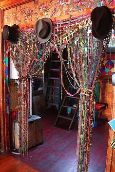 a room filled with lots of colorful beads and chains hanging from the ceiling next to a ladder