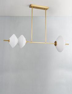 three lights hanging from a ceiling fixture in a room with white walls and flooring