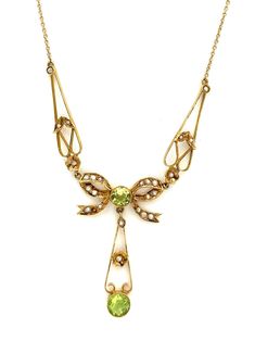 Bright green genuine Peridot is accented by seed pearls to form this cute and kitschy 14k yellow gold bow necklace! This was made during the US Art Nouveau artistic style period, where jewelry was often fashioned to represent an object. There are two genuine peridot gemstones, round brilliant cut and both are bezel set. The stone in the center of the bow measures 4.3mm and the larger stone at the bottom of the pendant drop measures 5mm. There is a total of 25 genuine seed pearls. The spring ring clasp of the chain is stamped '14KT', and the jump ring it attaches to is stamped '14k B.A.B'. The necklace is a total of 17 inches long and weighs 4.1g in total.  We will consider any reasonable offer on our items. All items are evaluated by a Gemological Institute of America (GIA) certified Gradu Heirloom Style Green Necklace For Gift, Bow Necklace, Peridot Gemstone, Seed Pearl, Gold Art, Drop Necklace, Spring Rings, Art Nouveau, Jewelry Necklace Pendant