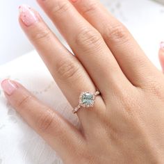 a close up of a person's hand with a diamond ring on their finger