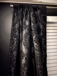 a black and white curtain hanging on the side of a window