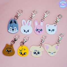 several key chains with cartoon faces on them, all in different colors and shapes to match