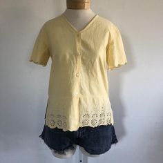 ★ sale! take 30% off 2 items, 40% off 3 items, and 50% off 4 items or more! discount automatically applies at checkout. ★This is a vintage pale yellow cotton top. Blouse is short sleeved with scalloped hem at the sleeves and the waist, buttons down the front, and cut out and sequin details on the bottom.era: 1990slabel size: S [please check measurements]fits like: small/mediummeasurements:bust: 38"hem: 38"length: 24"material: 100% cottonbrand/maker: Jane Ashleycondition: excellent vintage condit Vintage Cotton V-neck Top, Vintage Cotton V-neck Blouse, Retro Short Sleeve Tops For Spring, Vintage Yellow Tops For Spring, Classic Yellow Short Sleeve Tops, Cottagecore Cotton Short Sleeve Tops, Classic Yellow Summer Blouse, Cottagecore Short Sleeve Tops For Daywear, Cottagecore Short Sleeve Top For Spring