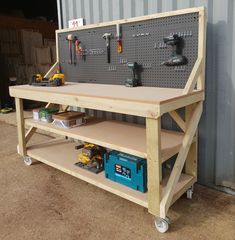 a workbench with tools on it sitting in front of a metal wall and door