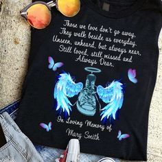 there is a shirt with an angel on it and other items next to it, including sunglasses