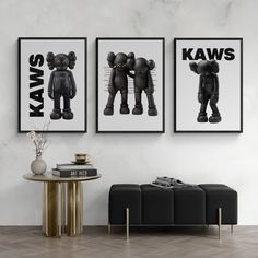 two black and white pictures hanging on the wall above a coffee table in a living room