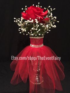 a vase filled with red roses and baby's breath in front of a black background