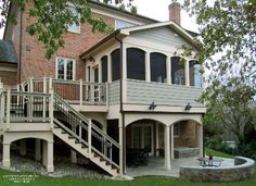 a large house with stairs leading up to the front door and second story deck area