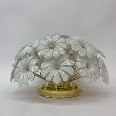 a white flower arrangement sitting on top of a gold stand