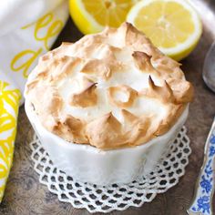 a close up of a pie on a doily with lemons in the background