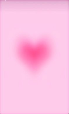 a blurry image of a red heart on a pink background