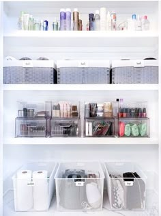 the inside of a white refrigerator filled with lots of containers and bins full of items