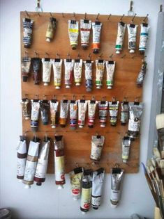 a wooden shelf with lots of paint tubes hanging from it's sides and the words 25 oil painting tips that you can't live without