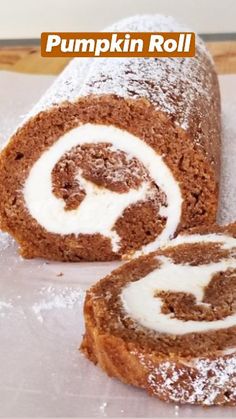 a cinnamon roll is cut in half and sitting on a piece of paper with powdered sugar