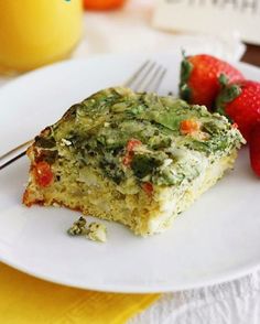 a piece of cake sitting on top of a white plate with strawberries next to it