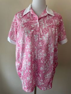 "Vintage 70s button down collared shirt. Collar and sleeves are white, two front waist pockets. Marked size 42, pink and white floral pattern. Please ask questions!  Measurements (laid flat):  Tag Size: 42 Length: 26.5\" Pit to Pit: 22.5\"x2 Waist: 24\"x2 Condition: Excellent vintage condition, no issues noted.  The vintage pieces I sell have all led a previous life and may tell their stories through minor imperfections. I'll do my best to indicate overall condition, but please refer to the pictures. Your purchase continues the life of this garment...what stories will you tell while wearing it?  Please note there may be a slight difference in color when comparing the actual garment to the monitor image. (0460)" Pink Collared Shirt With Pockets, Collared Pink Blouse For Daywear, Vintage Pink Button-up Blouse, Vintage Pink Button-up Shirt, Retro Pink Button-up Blouse, Vintage Pink Buttoned Shirt, Vintage Pink Shirt With Buttons, Pink Floral Print Collared Blouse, Pink Collared Shirt For Daywear