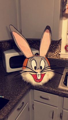 a kitchen counter with a microwave oven and cartoon head on top of the countertop