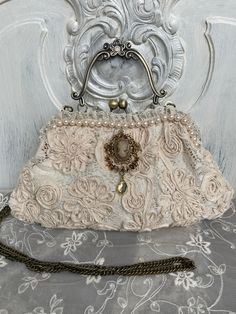 Magical bag made of a beautiful fabric in light beige Decorated with lace and pearls Width at bottom: 29 cm Width of temples: 20 cm Height from floor to bracket: 17 cm The chain is 120 cm long in total Chain and bracket bronze colored The bag is lined with cotton and decorated with lace inside Unique Tote Bag, Bridal Bag, Bag Hanger, Diy Bags Purses, Bag Light, Bronze Color, Diy Bag, Light Beige, Clutch Handbag