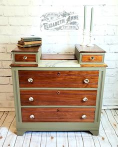 an old dresser is painted green and brown