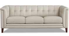 a white leather couch sitting on top of a wooden frame