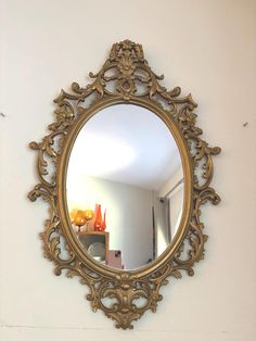 an ornate gold mirror hanging on the wall