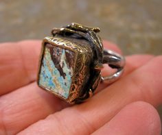 "A Beautiful Sterling Gilt Unique Artisan handmade Turquoise Ring Size 8. 13.61 Grams. Set Stone  Measures 5/8 x 2/8\" . Beautiful Gilt details with a lovely Ivy and Vine Naturalist Mount." Unique Bronze Rectangular Jewelry, Unique Rectangular Bronze Jewelry, Rectangular Patina Jewelry As Gift, Nature-inspired Jewelry With Patina As A Gift, Handmade Rectangular Artsy Jewelry, Handmade Collectible Artsy Jewelry, Handmade Artsy Collectible Jewelry, Artisan Ring With Unique Variations, Artisan Rings With Patina And Adjustable Fit