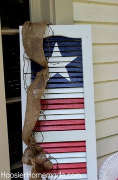 an old shutter is decorated with red, white and blue stripes for the fourth of july