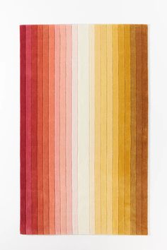 a multicolored rug with vertical stripes on the bottom, and an orange stripe in the middle