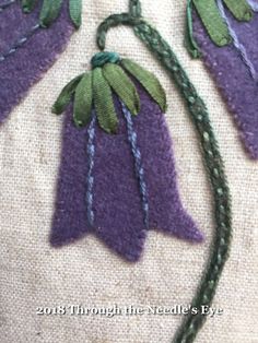 a close up of a piece of cloth with flowers on it and some thread in the middle