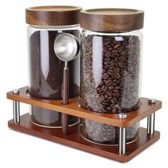 two jars filled with coffee beans on top of a wooden shelf