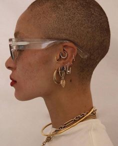 a close up of a person with glasses on their head and ear rings in front of her face