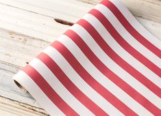 a red and white striped paper laying on top of a wooden floor