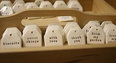 small ceramic tags with words on them sitting in a drawer