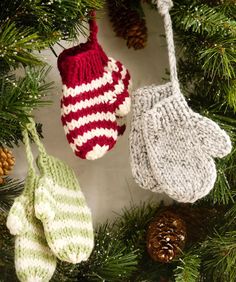 three knit mittens hanging from a christmas tree