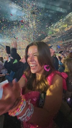 a woman in a pink dress at a concert with confetti falling from the ceiling