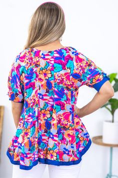 Product Details Colors: Blue, Teal, Orange, Hot Pink, Periwinkle, Purple, Brown Print: Floral Neckline: Round Sleeve: Short Sleeve Hemline: Straight Brand: Umgee Material and Care 100% Rayon Contrast: 100% Cotton Hand Wash Cold Hang/Line Dry Size and Fit Small: Bust 38" Waist 40" Front Length 25" Back Length 27" Medium: Bust 40" Waist 42" Front Length 25.5" Back Length 27.5" Large: Bust 42" Waist 44" Front Length 26" Back Length 28" Photo model is 5'7 and wearing a size small Playful Short Sleeve Blouse, Playful Multicolor Printed Top, Playful Multicolor All Over Print Top, Printed Blue Rayon Top, Blue Printed Rayon Top, Playful Floral Print Short Sleeve Tops, Flowy Multicolor Floral Print Tops, Flowy Multicolor Floral Print Blouse, Summer Multicolor Tops With All Over Print